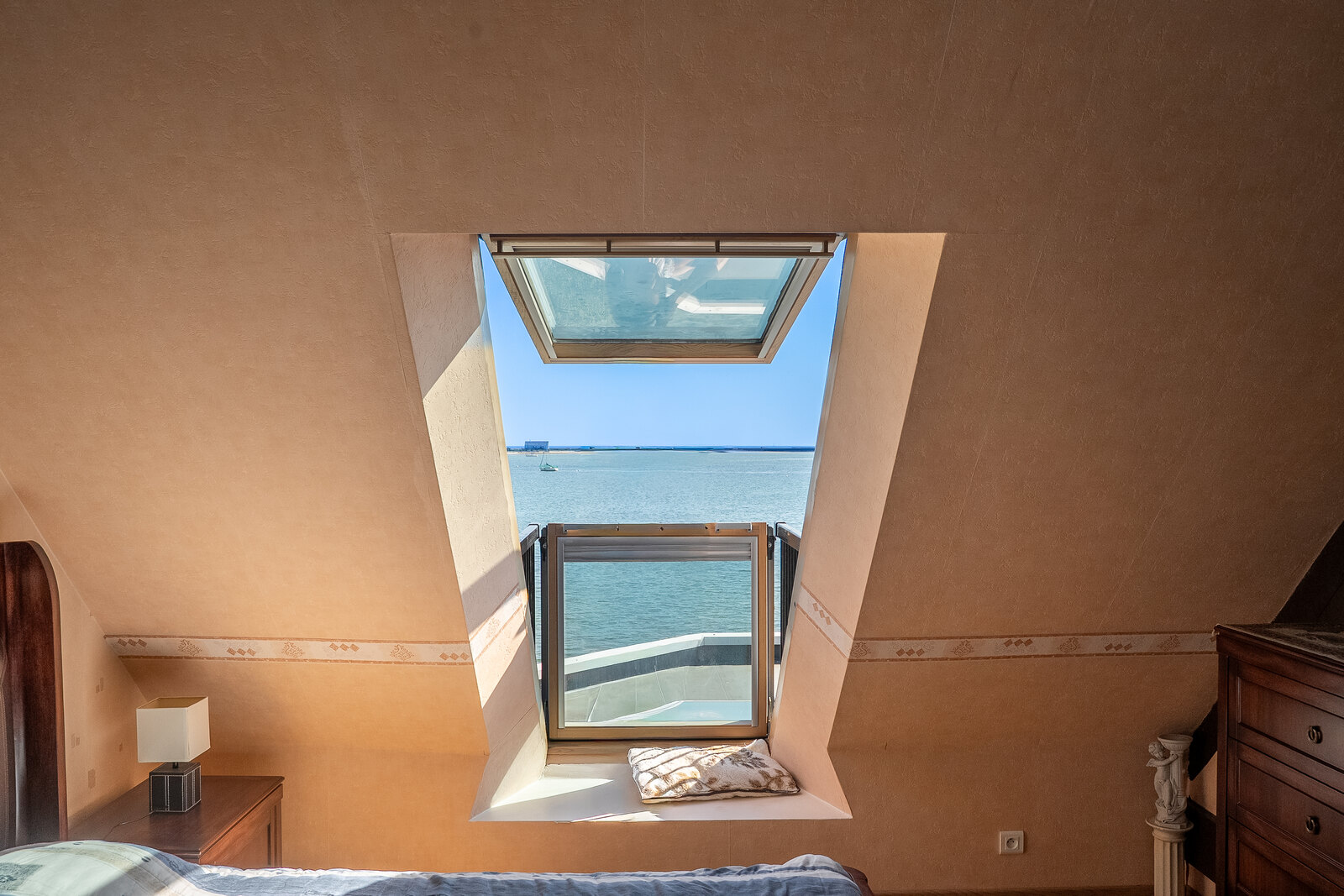 Une chambre, vue sur la mer par la lucarne